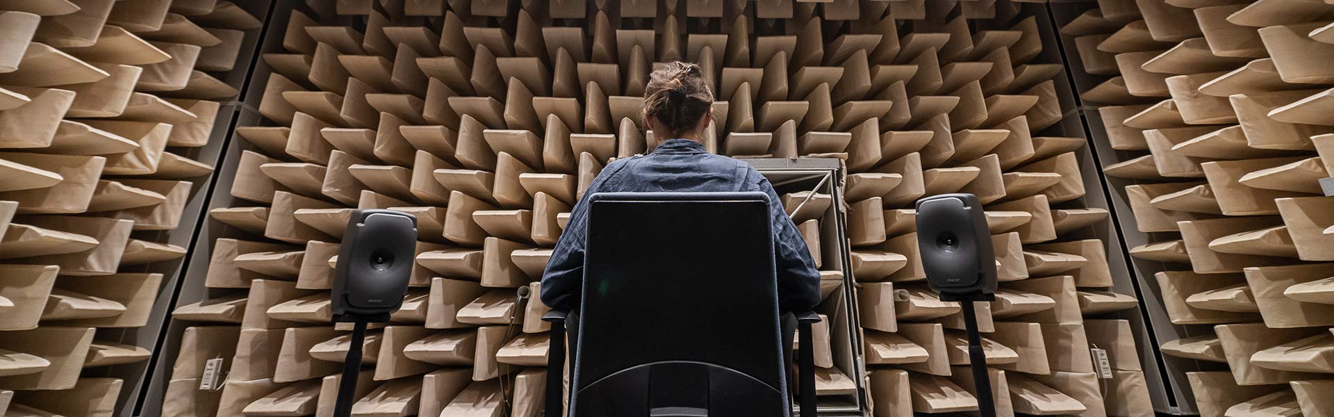 A test person takes part in a hearing research experiment in an anechoic chamber.