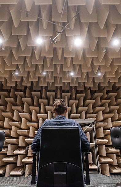 A test person takes part in a hearing research experiment in an anechoic chamber.