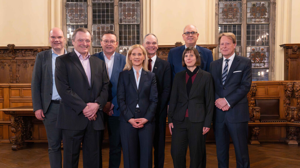 Acht Menschen stehen im Rathaus Bremen.