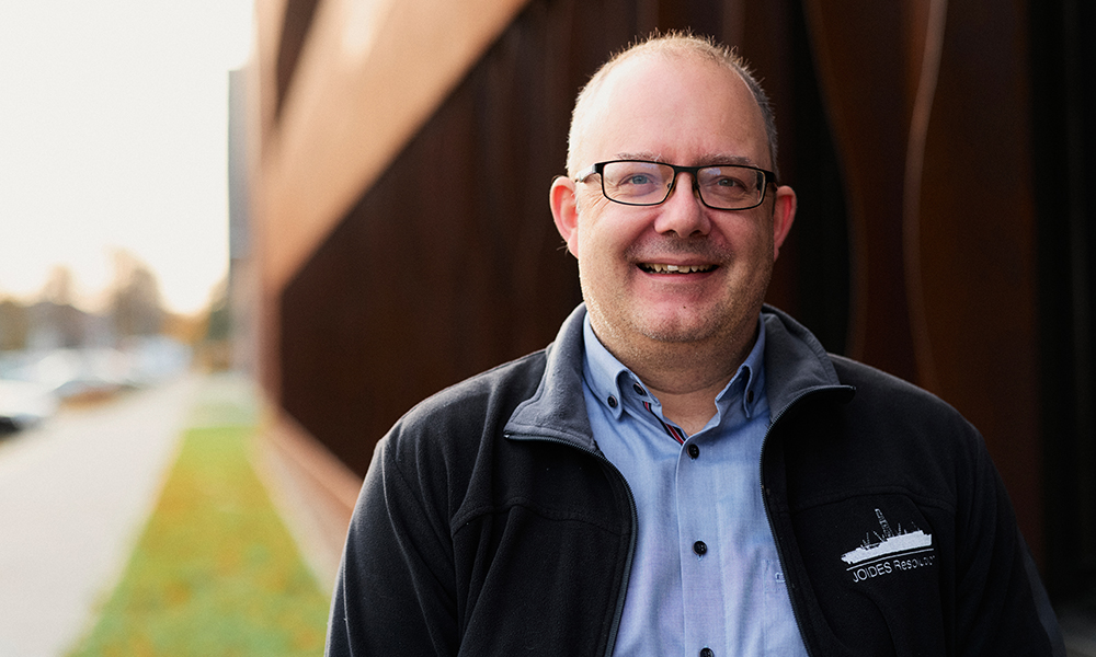 Portraitfoto von Heiko Paelike, lächelnd vor einem Gebäude