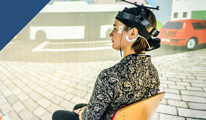 Eine Probandin nimmt an einem Hörforschungsexperiment in einem Reflexionsarmen Raum teil.