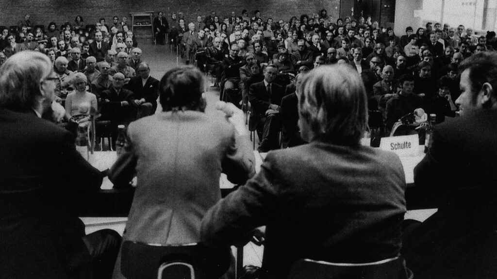 Vier Menschen reden zum Publikum.