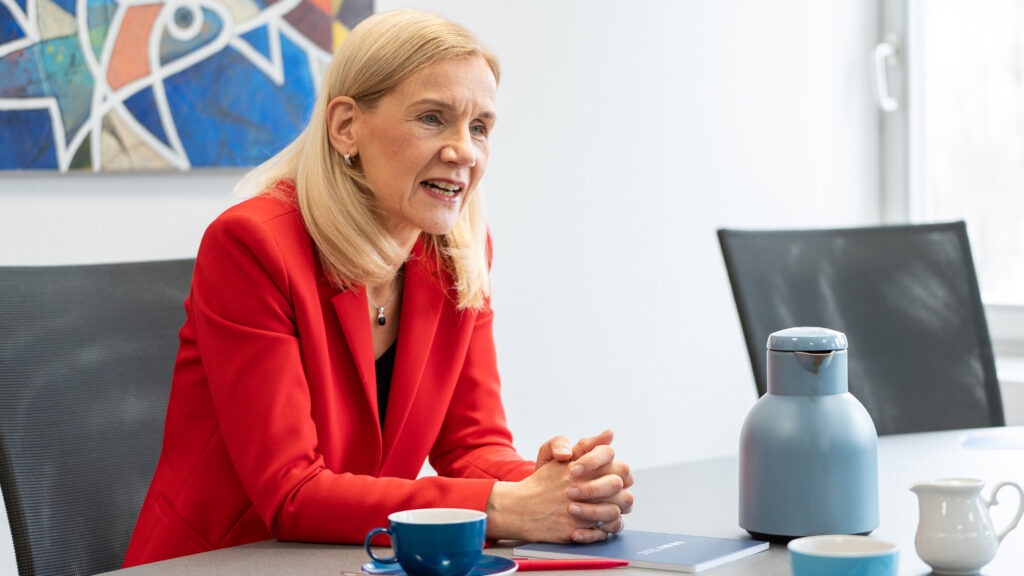Jutta Günther at the desk in an interview situation.