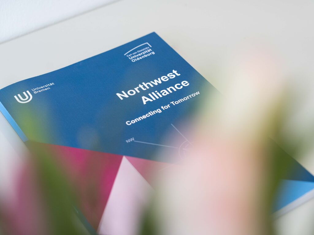 Eine Broschüre mit dem Schriftzug "Northwest Alliance - Connecting for Tomorrow" liegt auf einem Tisch.